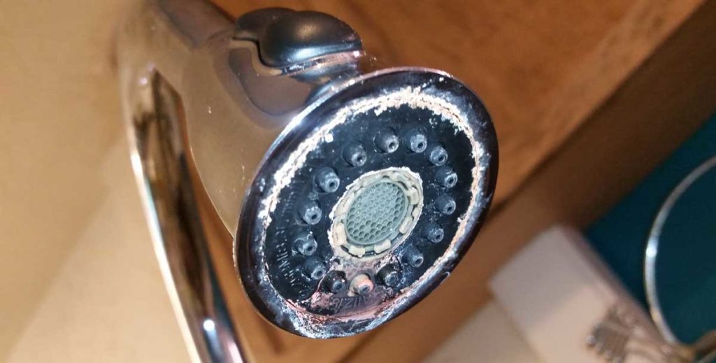 Limescale build-up on a kitchen sink faucet due to water hardness
